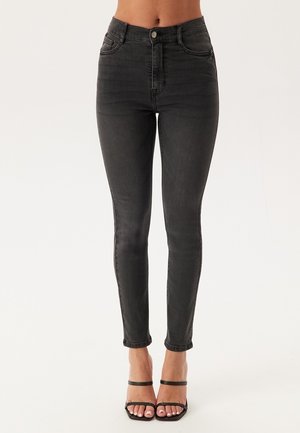 Hoge taille zwarte skinny jeans van denim, met voorzakken, subtiele vervaging en een ritssluiting met knoopsluiting.