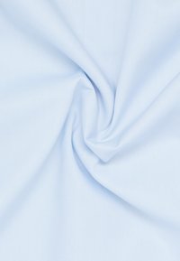 Lichtblauwe stof met een gladde textuur, gedeeltelijk gedraaid om de val en zachtheid te tonen, zonder duidelijke patronen of hardware.
