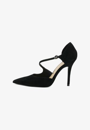 Chaussure à talon haut en suédine noire avec bout pointu et bride croisée à la cheville avec boucle argentée, vue de côté sur fond blanc.