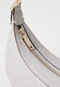 Gray handbag made of textured material, featuring a gold zipper, with a subtly patterned surface and rounded shape.