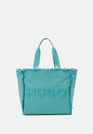 Turkusowa torba na ramię z rozdarciami na krawędziach i dwoma uchwytami, z wyszytym na przednim panelu napisem "HUGO".