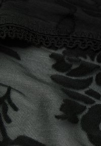 Černá krajka s květinovým vzorem a jemnou texturou, okraje zakončené zvlněným detailem, hladký a průhledný vzhled.