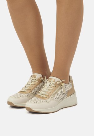Zapatillas con una combinación de colores beige y crema, que presentan un diseño perforado, acentos texturizados y una suela blanca acolchada. Detalles en hardware dorado.