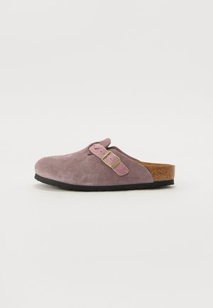 Zijden klompen in gedempt paars met een roze band en messing gesp detail. Kurk voetbed en zwarte rubberen zool. Gladde textuur. Zijaanzicht.