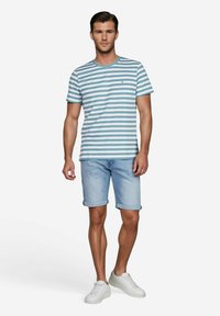 Gestreept t-shirt met korte mouwen in lichtblauw en wit, gecombineerd met lichtblauwe denim shorts en witte sneakers. Eenvoudig en casual ontwerp.