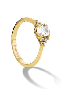 Goldring mit einem ovalen klaren Stein, umgeben von kleineren Steinen, mit einem eleganten Band und der Gravur "ROSEFIELD" im Inneren.