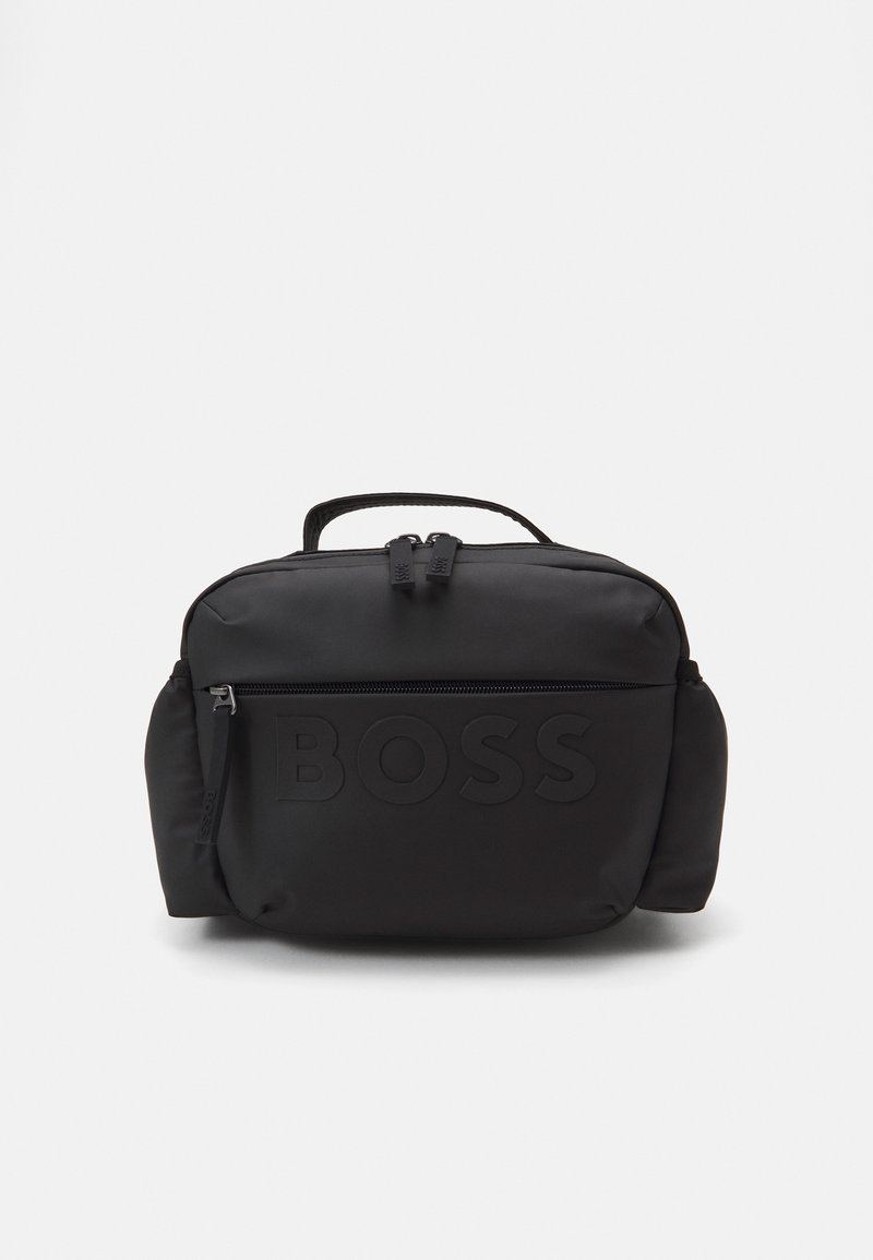 Juodas nailono krepšys su išpuoselėtu „BOSS“ logotipu, užtrauktuku, viršuje esančia rankena ir šoninėmis kišenėmis. Lygi tekstūra, apvalios formos.