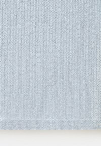 Tissu tricoté bleu clair avec un motif côtelé vertical, surface légèrement texturée et une couture horizontale près du bord inférieur.