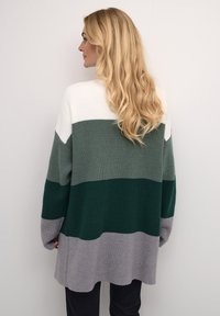 Texturált kötött kardigán vízszintes csíkokkal fehér, sötétzöld, világoszöld és szürke színekben. Lazán illeszkedő, hosszú ujjú és kerek fazonú.