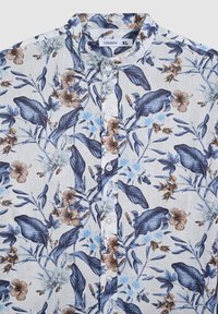 Camicia a maniche corte a fiori nei toni del blu chiaro, blu navy e marrone. Presenta una chiusura con bottoni, colletto a punta e una combinazione di motivi floreali grandi e piccoli.