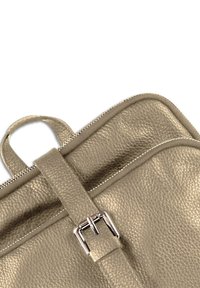 Grijze leren tas met een gestructureerd oppervlak, voorzien van een zilveren gesp en een ritsluiting. Bovenste handvat voor draagcomfort.