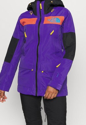 Purple and black North Face jacket with orange accents, yellow zipper pulls, front pockets, and adjustable hood worn by a person.