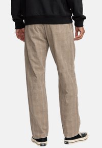 Beige geblokte broek met een ontspannen pasvorm, gemaakt van gestructureerde stof, met een subtiel ruitpatroon en zijzakken.