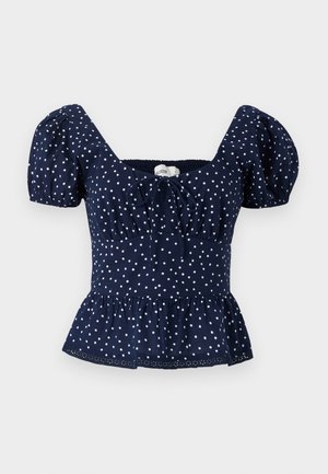 Temno modra bluzica s pikami, napihnjenimi rokavi, kvadratnim izrezom in peplum završkom. Narejena iz lahkotnega materiala, z vezavo na prsih.