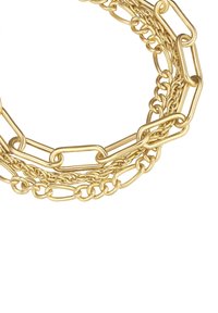 Zlatý reťazový náhrdelník s prepletenými článkami rôznych veľkostí a textúr, hladké a skrútené dizajny poskladané dohromady.