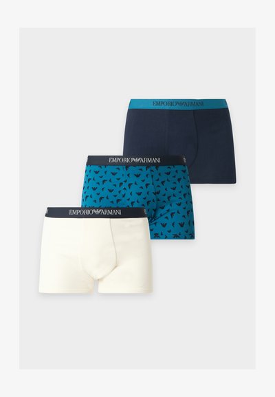 Τρία ανδρικά boxer Emporio Armani σε λευκό, μπλε με μοτίβο λογότυπου και μονόχρωμο σκούρο μπλε, όλα με λουράκια με λογότυπο.