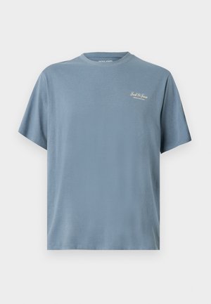 T-shirt en coton bleu clair avec col rond, manches courtes et un petit logo blanc imprimé sur le côté gauche de la poitrine. Texture lisse, design décontracté.