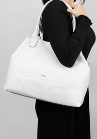 Witte leren tote bag met een gestructureerde afwerking, voorzien van een gouden logodetail en dubbele schouderbanden. Gestructureerde vorm met een ruime binnenkant.