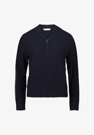 Marineblå zip-up cardigan lavet af struktureret strikket stof, med en rund krave, to forlommer og en lille cirkulær lynlåsgreb.