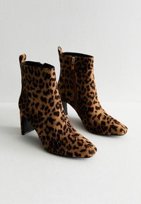 Bottines en suède à imprimé léopard, avec un bout pointu et des talons blocs noirs, dotées d'une fermeture éclair latérale et d'une languette au dos.
