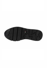 Suela de zapato de goma negra con patrón de banda vertical y en zigzag, con el nombre de la marca en relieve en el lateral. Detalle de la bandera italiana incluido.