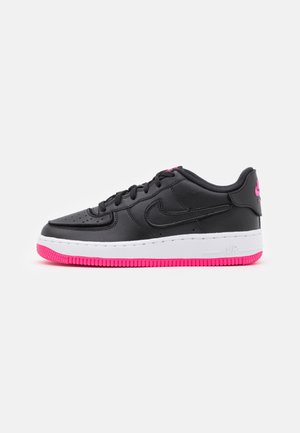 Czarne niskie buty sportowe Nike Air Force 1 z różową podeszwą zewnętrzną i różowym logo Nike na pięcie, białą śródpodeszwą oraz czarnymi sznurowadłami.