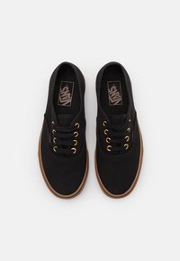 Sneaker nere in tela con occhielli dorati, punta rotonda, suola in gomma e suola esterna marrone. Logo visibile sulla soletta.