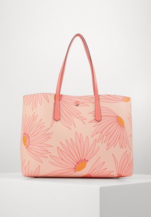 Roze tas met grote madeliefpatronen in oranje en roze en dubbele roze handvatten, tentoongesteld op een wit voetstuk.