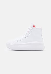 Białe wysokie trampki z grubą gumową podeszwą, białymi sznurowadłami, metalowymi oczkami i różowym wnętrzem, przedstawione z boku na jednolitym tle.