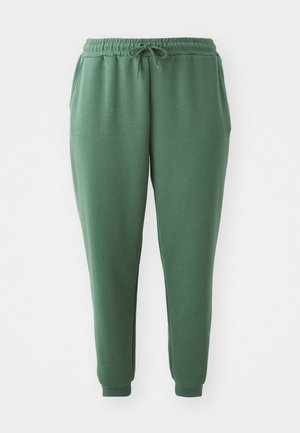 Zelené tepláky vyrobené z měkké látky s elastickým pasem, šňůrkou a zúženými manžetami. Disponují bočními kapsami pro pohodlí.