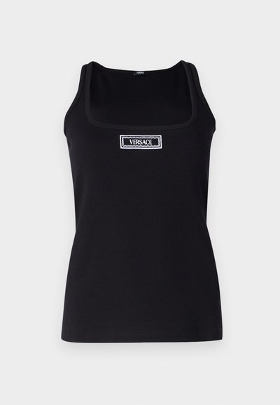 Μαύρο τοπ από βαμβάκι, με τετράγωνη λαιμόκοψη και λεπτά λουριά. Ένας λευκός ετικέτα με την ένδειξη "VERSACE" είναι ραμμένη μπροστά.