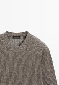 Maglione marrone a costine con collo tondo, caratterizzato da un motivo a maglia testurizzata e un'etichetta con "Massimo Dutti" all'interno del colletto.