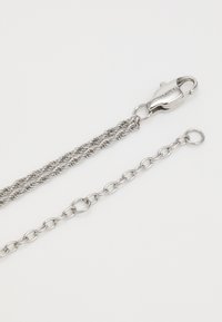 Collana in argento con doppia catena a corda, dotata di un gancio a moschettone inciso "HILFIGER" e un estensore a catena, su sfondo bianco.