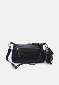 Černá kožená crossbody taška se zlatým zipem, odnímatelnou malou kapsou a nastavitelným popruhem. Hladký povrch s minimálním hardwarem.