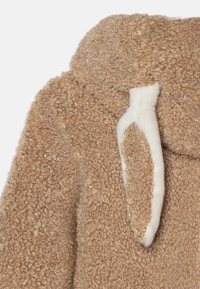 Brown, fluffy fleece jacket with a textured surface and a white-lined hood. Features pronounced bunny ear accents near the neckline.