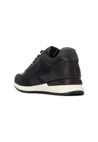Zapatilla negra y gris oscuro con parte superior de cuero texturizado, detalles lisos y una media suela blanca. Presenta un diseño deportivo y un talón acolchado.
