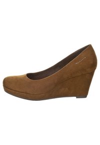 Zapatos de cuña de ante marrón con punta redonda y un tacón ligeramente elevado. Textura suave y diseño minimalista. Logotipo impreso en el lateral.
