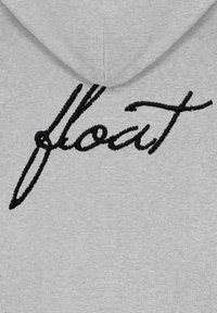 Felpa grigia con testo corsivo ricamato in nero "flout" sulla parte posteriore. Il materiale sembra morbido con una superficie liscia e cappuccio.