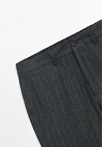 Dark gray striped trousers with an elastic waistband and a single button closure. Made of a smooth fabric, featuring subtle vertical lines.