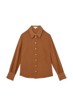 Valkoinen pitkähiha shirt valmistettu sileästä kankaasta, jossa on suuri kaulus ja helmipainike sulkeminen edessä. Hihansuut ovat hieman kerättyjä.