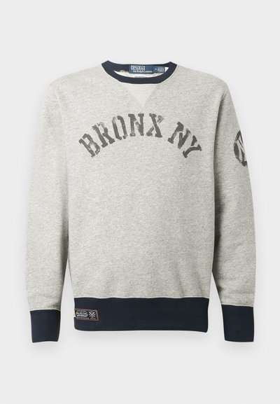 Moleton cinza com o texto "BRONX NY" no peito, gola, punhos e barra em azul-marinho, e um pequeno emblema perto da barra inferior.