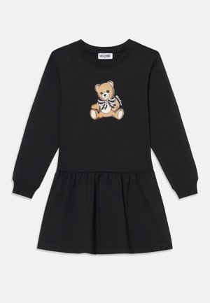 Vestido negro de manga larga con falda acampanada, que presenta un gráfico de un oso de peluche en la parte delantera. Está hecho de una tela suave con un ajuste cómodo.