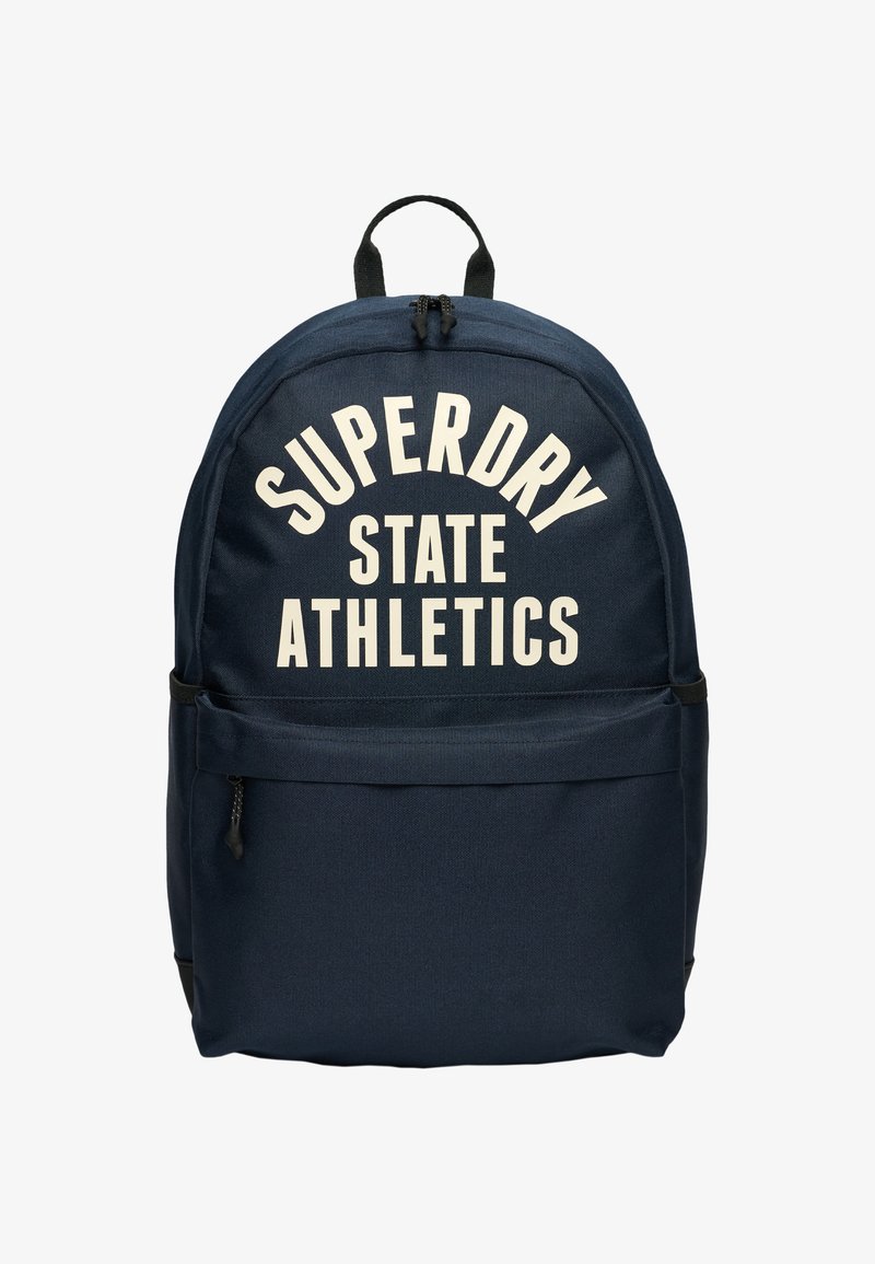 Sac à dos bleu marine avec une poche zippée à l'avant et un texte blanc indiquant "SUPERDRY STATE ATHLETICS" sur le compartiment principal.