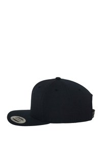 Fekete snapback sapka lapos karimával, szövet textúrával, hat paneles kialakítással és hímzett szellőző nyílásokkal. A belső oldalon márkafelirat található.