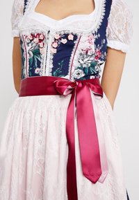 Sukienka dirndl z granatowym kwiatowym gorsetem ozdobionym koronką, różową satynową wstążką oraz fakturowaną różową koronkową spódnicą.