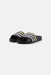 Schwarze Rutsch-Sandalen mit mehreren horizontalen Streifen in pastellfarbenen Tönen: Lavendel, Blau, Minze und Gelb. Weiches Material, offenes Design.