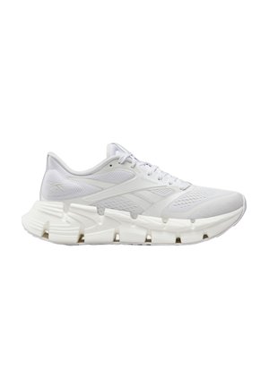 White athletic sneaker with textured mesh upper, geometric segmented sole, lace-up closure, and subtle brand logo on side and heel.