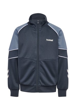Mørkeblå og grå sportstrøje med lynlås, høj krave, elastiske manchetter, hvide chevron-striber på ærmerne og "hummel"-logo på brystet.