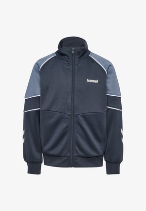 Mørkeblå og grå sportstrøje med lynlås, høj krave, elastiske manchetter, hvide chevron-striber på ærmerne og "hummel"-logo på brystet.