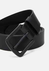 Black leather belt featuring a matte black metal buckle with a prong fastening, smooth texture, and no visible patterns or accents.